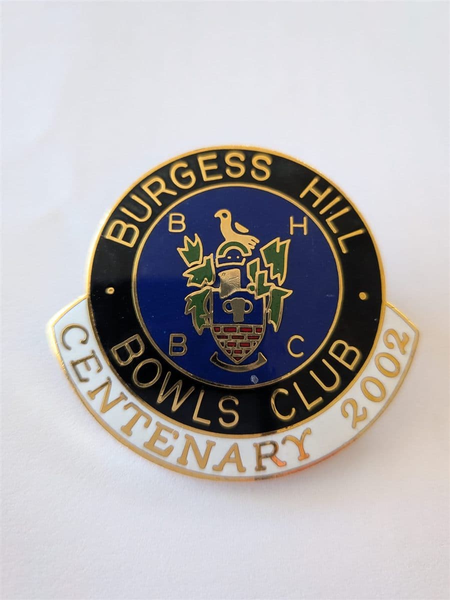 Enamel pin badge reading Burgess Hill Bowls Club, Centenary 2002, with the town crest on a blue background